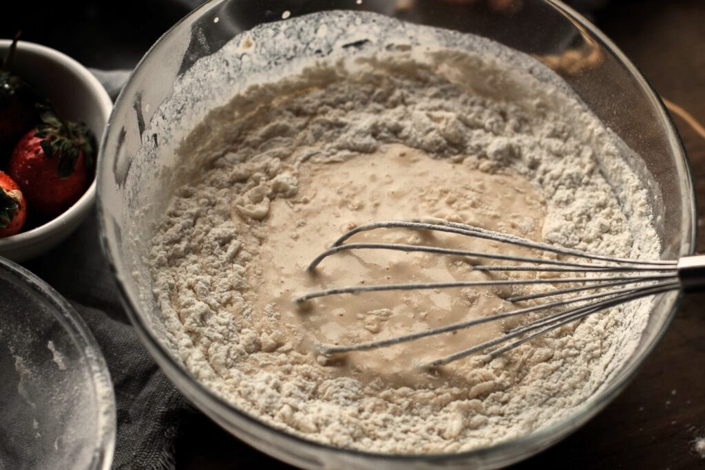 close up of whisk in bowl of batter